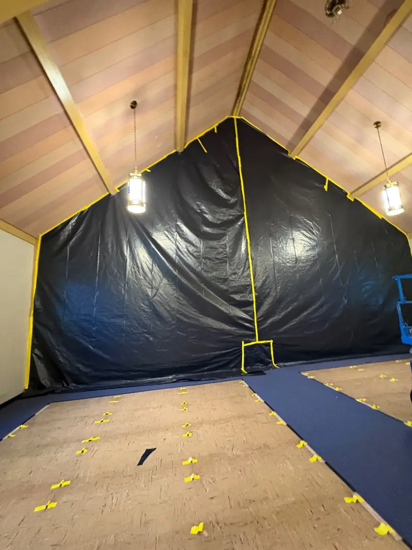 Black containment sheeting with a zippered entry built inside the church sanctuary before mold remediation began